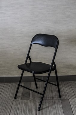 black metal with vinyl padding folding chair for rent has padding on both backrest and seat