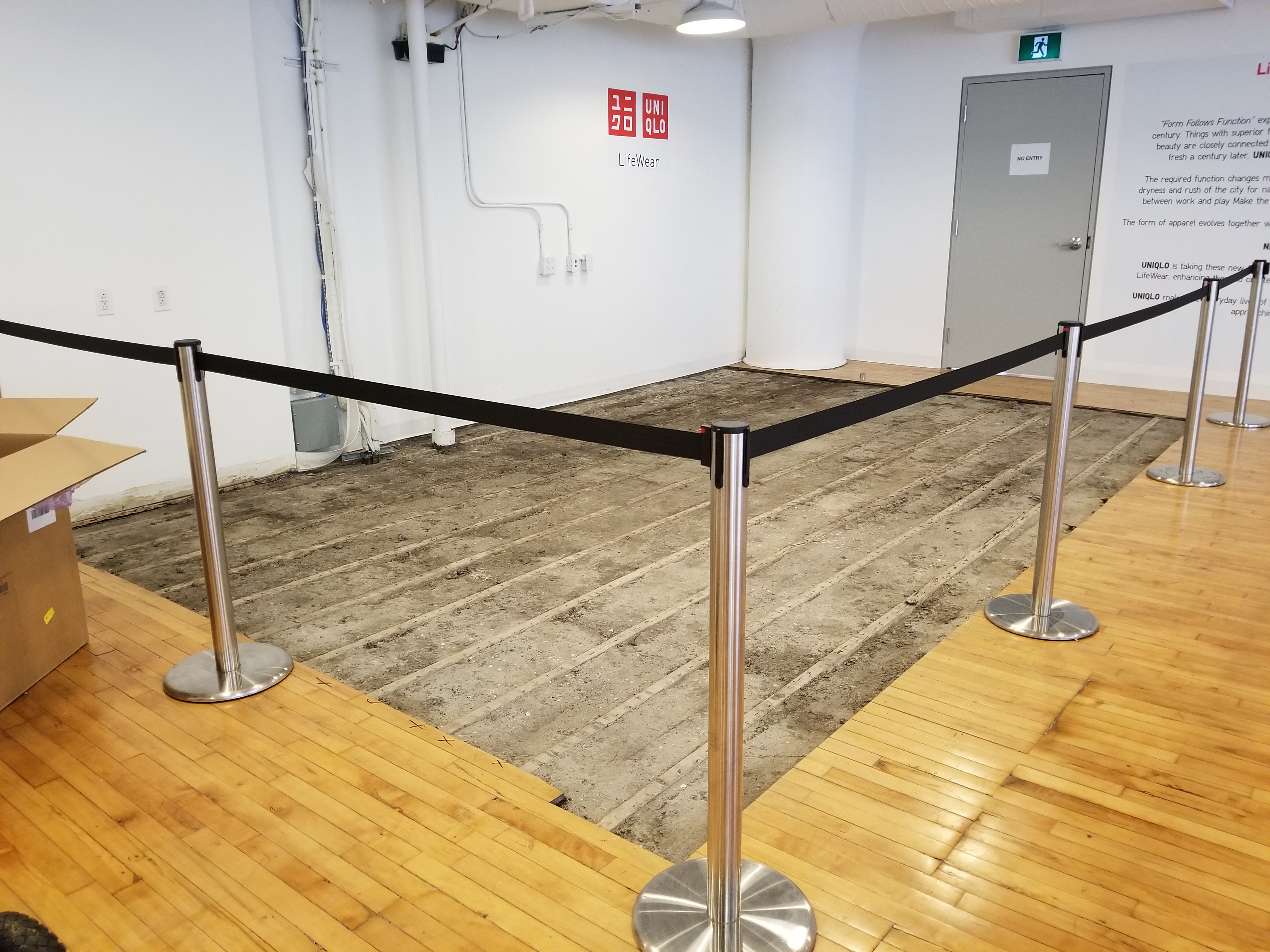 Chrome stanchions with black retractable belt seperating section of venue that is undergoing renovations